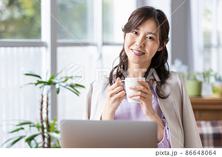 マグカップを持ったリモートワーク中の女性 86648064