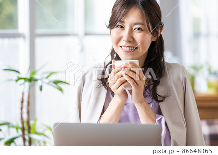 マグカップを持ったリモートワーク中の女性 86648065
