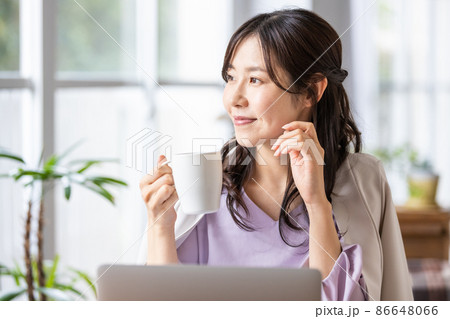 マグカップを持ったリモートワーク中の女性 86648066