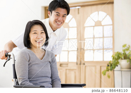 介護イメージ　男性介護士と車椅子のシニア女性 86648110