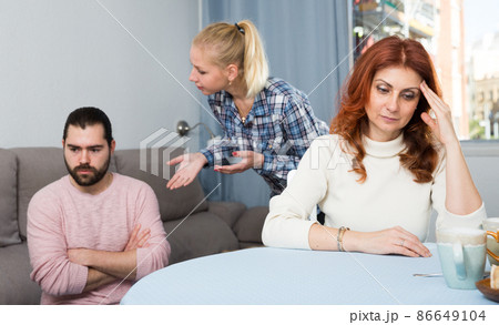 Husband and wife quarrelling indoors, senior mother taking it hard 86649104
