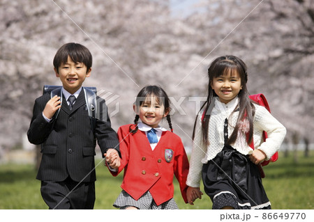 桜並木の前で笑う新一年生と園児 桜並木の前で笑う新一年生と園児 86649770