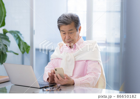 シェアオフィスで仕事をするシニア男性 86650182