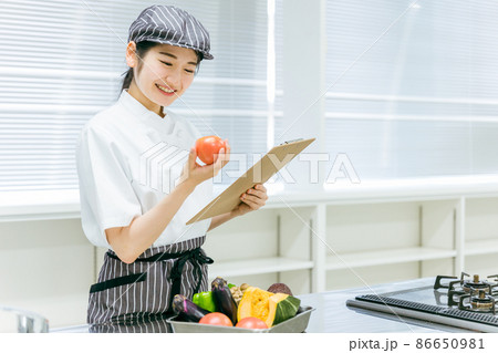 食品をチェックする女性(トマト・笑顔) 食品をチェックする女性(トマト・笑顔) 86650981