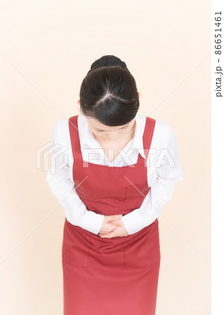 お辞儀をするエプロンの女性 お辞儀をするエプロンの女性 86651461