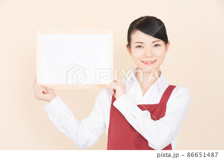ホワイトボードを持つエプロンの女性 86651487