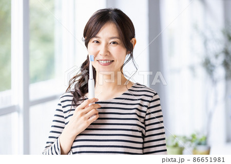 電動歯ブラシで歯を磨こうとしている女性 86651981