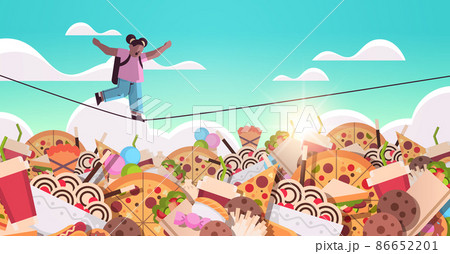 schoolgirl balancing on rope above junk food assortment of fast food unhealthy nutrition junkfood addiction 86652201