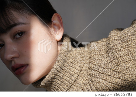 セーターを着た女性の陰影のあるポートレート 86655793