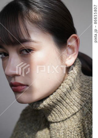 セーターを着た女性の陰影のあるポートレート 86655807