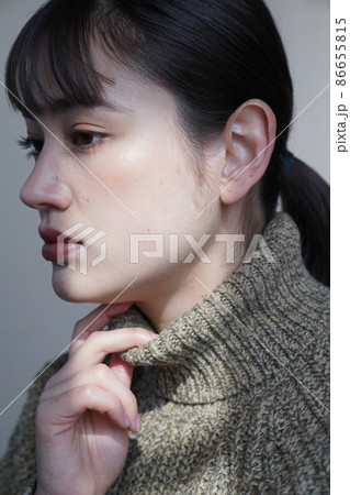 セーターを着た女性の陰影のあるポートレート 86655815