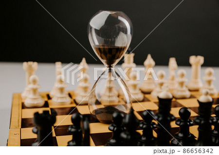 Hourglass stands on a chessboard. Leadership and business strategy concept Hourglass stands on a chessboard. Leadership and business strategy concept 86656342