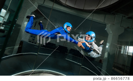A man and a woman enjoy flying together in a wind tunnel. Free fall simulator 86656778