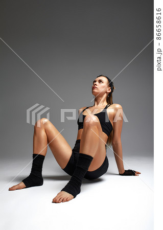 Portrait of female anger, animal instinct, demonstrating their incredible flexibility with the movement of animal flow in the studio on a gray background. 86658616