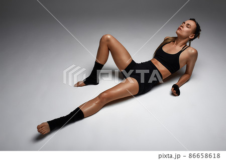 Portrait of female anger, animal instinct, demonstrating their incredible flexibility with the movement of animal flow in the studio on a gray background. 86658618