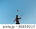 Athlete jumps and kicks a volleyball. Summer sport Beach volleyball. 86659215
