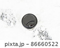 A large disposable paper cup with a lid for hot drinks on a snowy background. 86660522