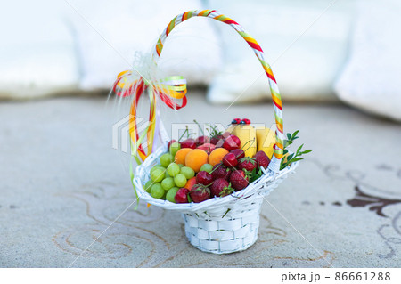 Basket and fresh fruits on table 86661288