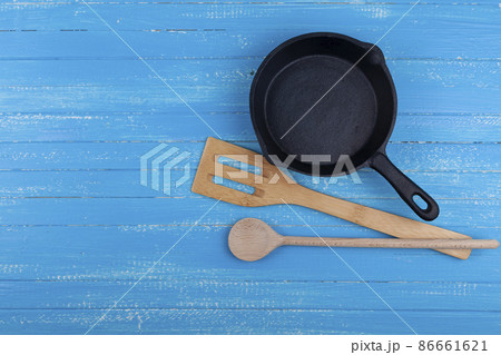 Empty cast iron pan on a blue wooden background. Empty cast iron pan on a blue wooden background. 86661621