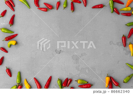 Mini chili peppers scattered on gray background top view Mini chili peppers scattered on gray background top view 86662340
