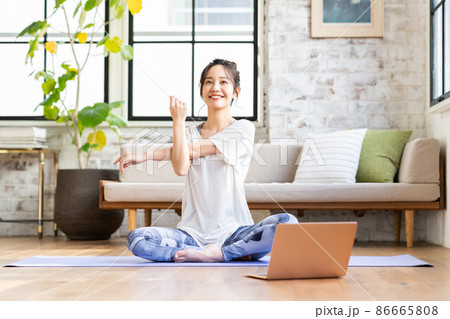 家でオンラインヨガをする若い女性 86665808