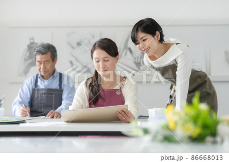 カルチャースクール　水彩画教室に通うシニア女性と男性　若い女性講師 86668013