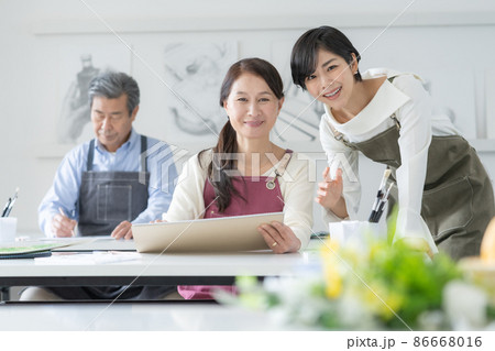 カルチャースクール　水彩画教室に通うシニア女性と男性　若い女性講師 86668016