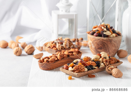 Mix of nuts and raisins on a white wooden table. 86668686