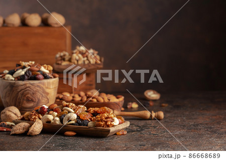 Mix of nuts and raisins on a brown rustic background. Mix of nuts and raisins on a brown rustic background. 86668689