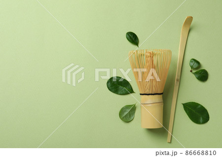 Japanese tea accessories on green background, space for text Japanese tea accessories on green background, space for text 86668810