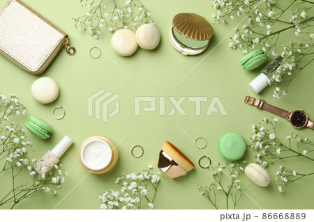 Female accessories and macaroons on green background 86668889