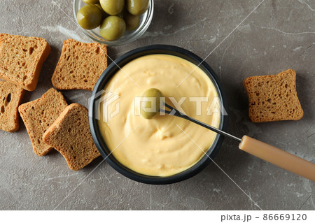 Concept of delicious food with fondue on gray textured table 86669120