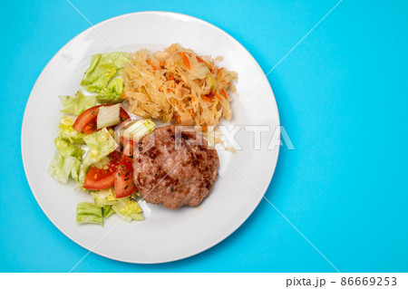 grilled hamburger with salad and salted salas cabbage with carrot on white plate grilled hamburger with salad and salted salas cabbage with carrot on white plate 86669253