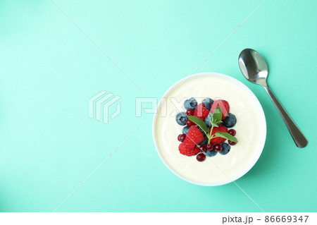 Concept of tasty breakfast with yogurt on mint background 86669347