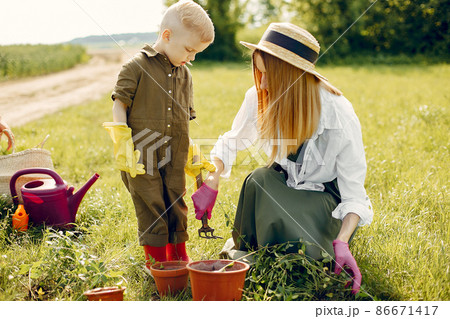 Beautiful mother with little son in a summer field Beautiful mother with little son in a summer field 86671417