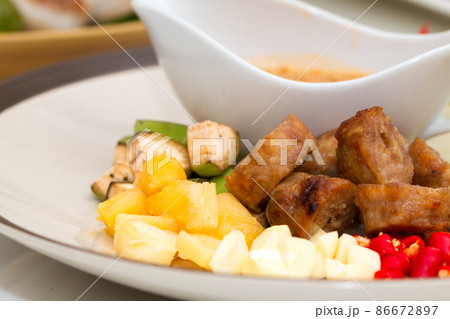 Close up of Namnueng with sliced banana pine apple chilli and dipped sauce on white plate 86672897