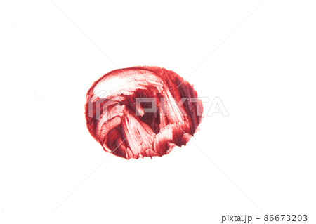 The lipstick print stands out against a white isolated background. Close-up of the creamy texture of makeup. Coral color of the cosmetic product. High quality photo 86673203