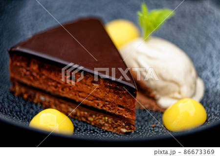 Dark chocolate tart with orange gel and artichoke ice cream Dark chocolate tart with orange gel and artichoke ice cream 86673369