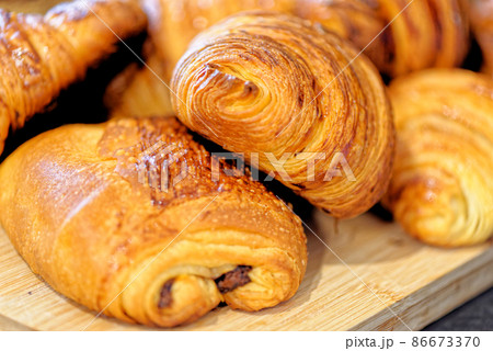 Fresh croissants and pain au chocolate on a plate Fresh croissants and pain au chocolate on a plate 86673370