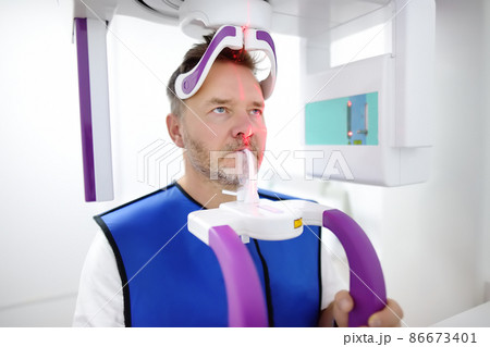 Man patient during a panoramic radiography in dentistry clinic. Modern dental equipment Man patient during a panoramic radiography in dentistry clinic. Modern dental equipment 86673401