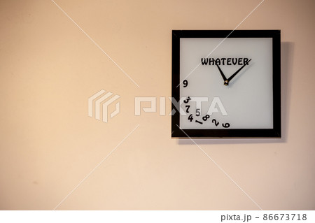 a square clock without numbers hangs on the wall. A watch with an inscription whatever. 86673718