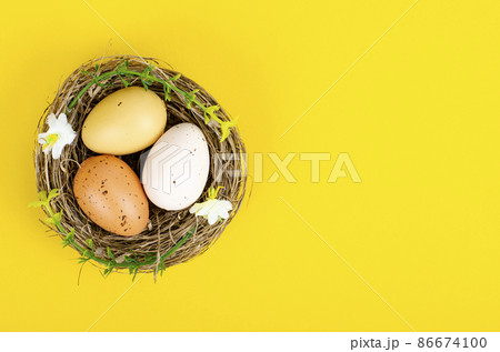Top view of color easter haqndmade eggs and nest flatlay. Trendy minimal design spring background. Space for text. Stuio Photo 86674100