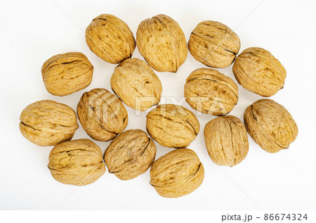 Unpeeled ripe walnuts on white background. Studio Photo Unpeeled ripe walnuts on white background. Studio Photo 86674324