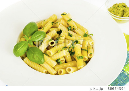Penne pasta with spinach basil pesto sauce on white plate. 86674394
