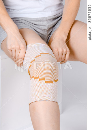 Knee Support Brace on leg isolated on white background. Elastic orthopedic orthosis. Anatomic braces for knee fixation, injuries and pain. Protective knee joint bandage sleeve. Trauma, rehabilitation. Knee Support Brace on leg isolated on white background. Elastic orthopedic orthosis. Anatomic braces for knee fixation, injuries and pain. Protective knee joint bandage sleeve. Trauma, rehabilitation. 86675659