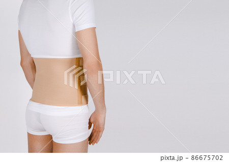 Orthopedic lumbar corset on the human body. Back brace, waist support belt for back. Posture Corrector For Back Clavicle Spine. Post-operative Hernia Pregnant and Postnatal Lumbar brace after surgery. 86675702