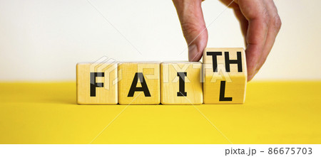 Faith instead fail symbol. Businessman turns a wooden cube and changes the word fail to faith. Beautiful yellow table, white background. Business and faith instead fail concept. Copy space. 86675703
