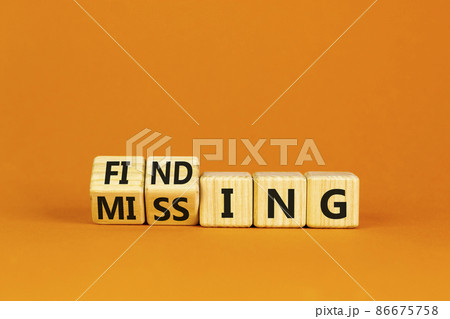 Finding or missing symbol. Turned wooden cubes and changed the word missing to finding. Beautiful orange background. Business, finding or missing concept. Copy space. 86675758