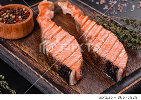 Grilled salmon with herbs served on black concrete table 86675828