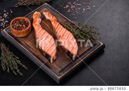 Grilled salmon with herbs served on black concrete table Grilled salmon with herbs served on black concrete table 86675830
